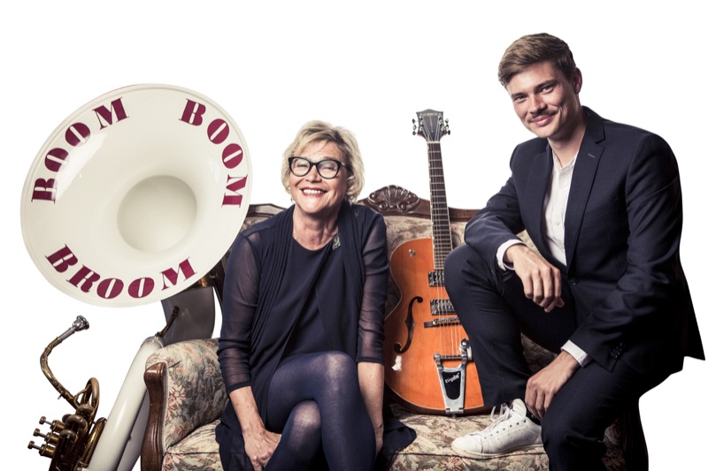 Heike Besen und Julius auf einem Sofa, neben ihnen Gitarre und Sousaphon, Frühjahr 2019.