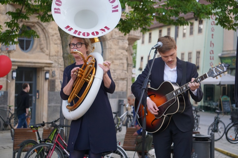 Heike Besen am Sousaphon und Julius an der Gitarre auf dem Holzmarkt in Jena.