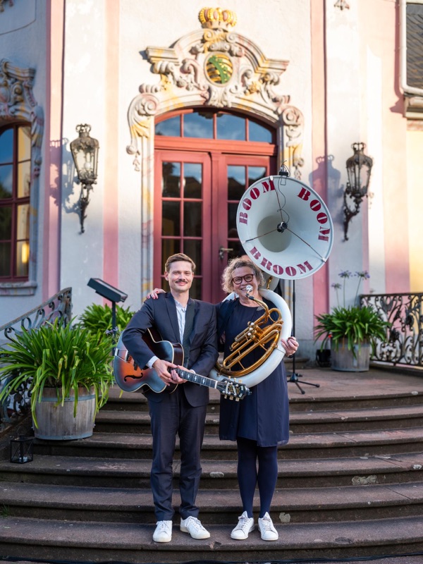 Heike Besen mit Sousaphon und Julius mit Gitarre auf der Treppe vor einem Schlossportal bei der Dornburger Schlössernacht.